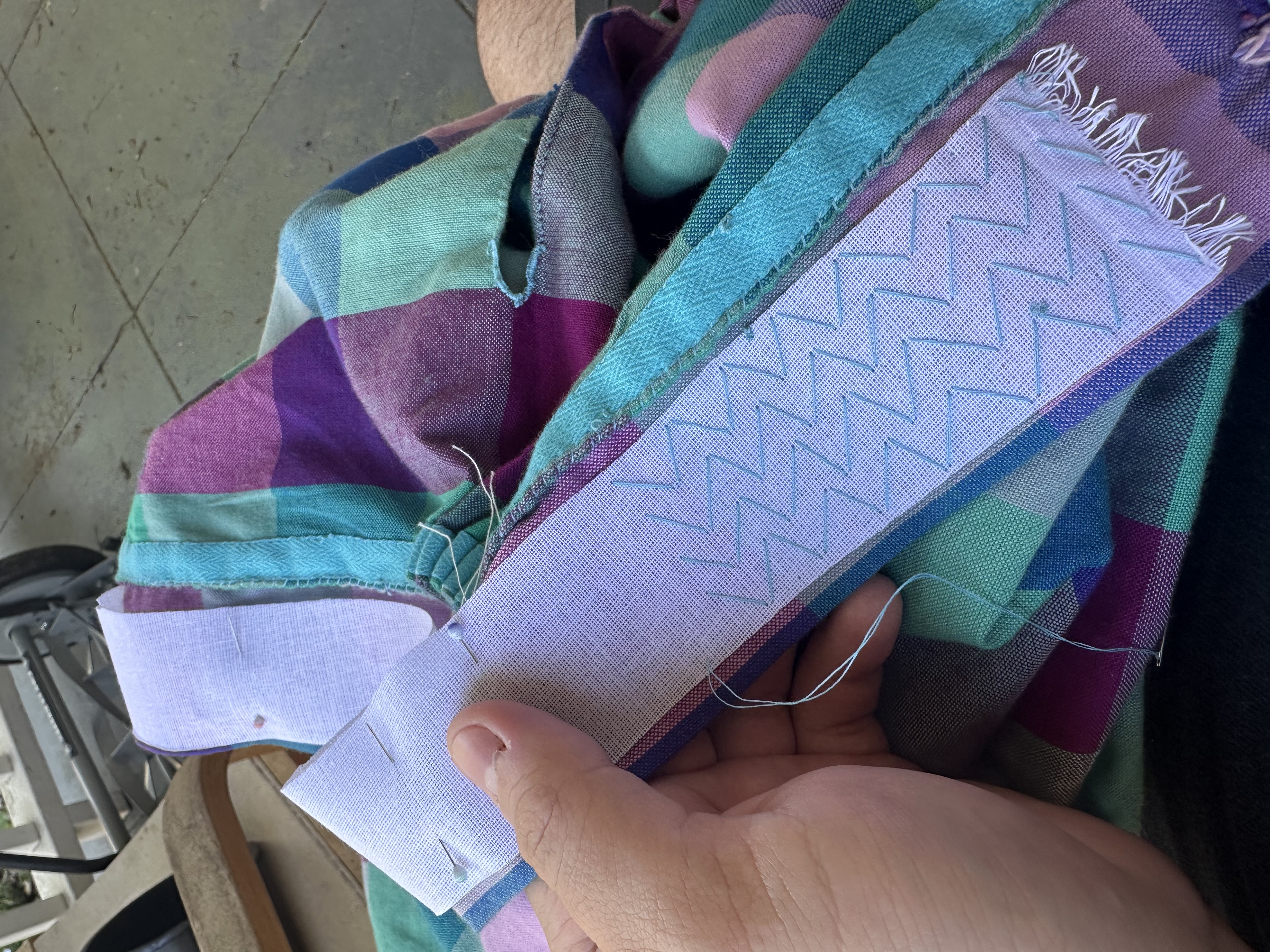 Pad stitching in bright blue being worked on the waistband.